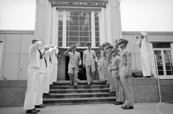 Lt. Commander Wallace E. Zabler salutes the Navy and Marines in the review of troops who officially "piped him over the sides" at his retirement ceremonies Friday. He retired from twenty-three years of Navy service and served two years as Commander of the Naval and Marine Corps reserve training center in Madison. In 1942 Zabler was captured in Java, Indonesia, as a POW and sold to the Japanese for $7.50. He was imprisoned for forty-two months in Bangkok, Thailand.