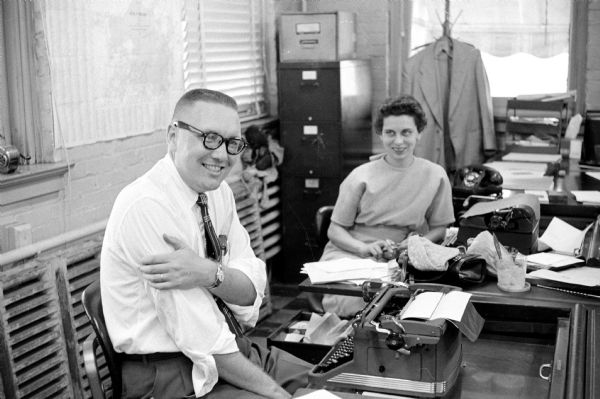 Man and woman in an office, probably at the <i>Wisconsin State Journal</i>. Ed Stein was testing the new Kodak Tri-X film ASA 800 & 650, when taking their picture.