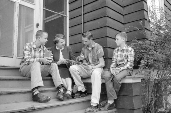 Brothers Malcolm, Mathew and Sidney Bourne discussing their finances as newspaper delivery boys with their mother, Mrs. Bailey Bourne, at their home on Lathrop Street before they go to Anchor Savings and Loan to deposit their earnings.    