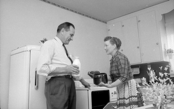 Anne Marshall Kleist, owner of the ladies' ready-to-wear and accessories store Kleist & Wiggs, gets help with dinner from her husband, Al, at home in the kitchen.