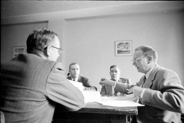 Members of the Rules Committee confer at the Democratic Party State Convention at the Hotel Loraine. Left to right are: Fred Winrich, Eau Claire; Clarence Bylsma, Madison; Assemblyman Allen Flannigan, Milwaukee; and John Reynolds.