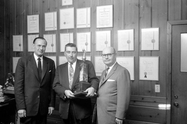 Richard W. Vesey (center) is holding a trophy he received from the <i>Inland Daily Press Association</i> for top award as reporter-photographer. It was presented by Don Anderson (left) of the <i>Wisconsin State Journal</i> publisher and Lawrence H. Fitzpatrick (right), managing editor.   