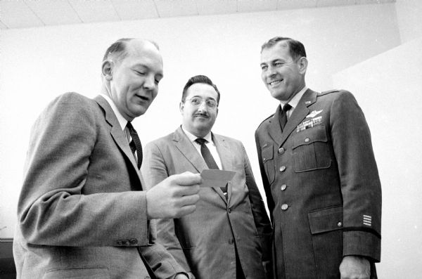 Tickets for the U.S. Air Force Band concert at the Orpheum Theater are presented to Madison Mayor Ivan Nestingen (left) by Colonel John H. Pease (right), Base Commander of Truax Field, and Glenn M. Lyans (center) (1110 Gilbert Road), member of the Madison Municipal Band and sponsor of the concert.