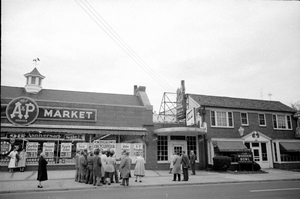 Members of the jury for the murder trial of Ralph O'Dell accused of shooting Joseph Knock during a burglary attempt, are standing in front of the A&P Supermarket at 2560 University Avenue. Circuit Judge Edwin Wilkie (arm raised) is pointing out the adjacent Lake Lanes bowling alley where the pinsetter was murdered.