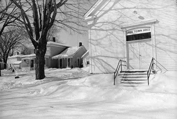 Leon Town Hall at 20490 Wisconsin Highway 27, next to a house in Monroe County, in the winter with snow on the ground.
