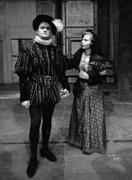 Actors in elaborate costumes for the first Wisconsin Players show of the season, "All's Well That Ends Well." William Dunlop of Milwaukee who plays Bertram, bids farewell to Shirley Mezvinsky (Madison), as his wife, Helena. The play was held in the Wisconsin Union Theater.