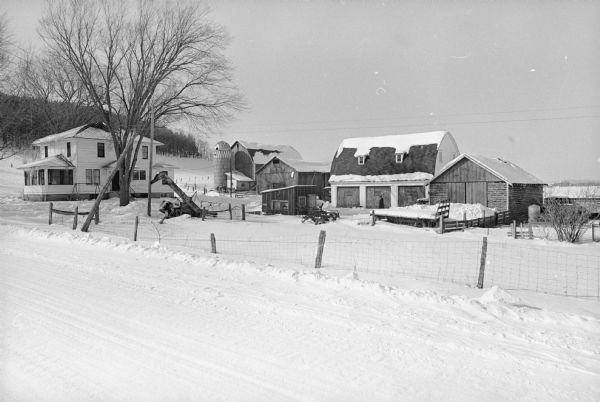 Winter view from the road towards the farmhouse and outbuildings of Charles and Victoria Slayton, parents of astronaut Donald "Deke" Slayton. The farmstead is located at 7432 Jaguar Avenue, on the southwest corner of Section 3 in the Town of Leon, Monroe County.