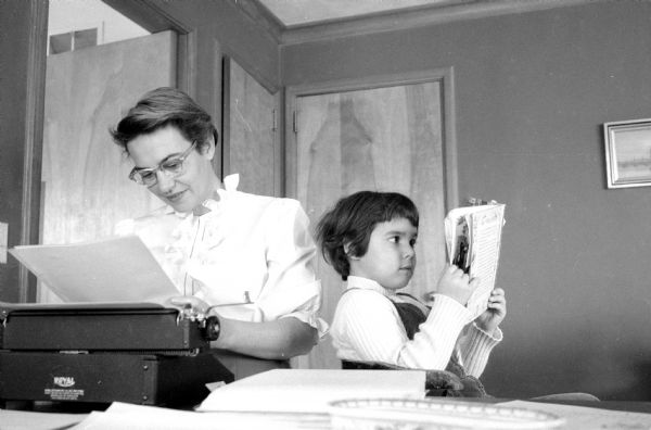 At the typewriter is Marie Teresa Rios Versace, mother of five children. At her side, daughter Tracy is reading a book. Versace has published her first book <i>An Angel Grows Up</i>. 