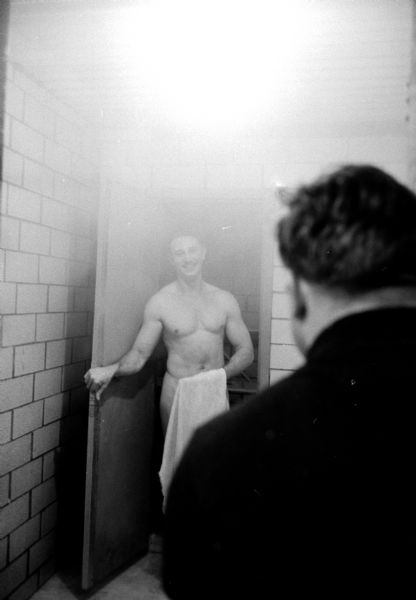 Robert Workman emerging from the steam room into the shower room at the Madison Health Studio at 235 West Gilman Street. He is holding a towel in front of his waist.