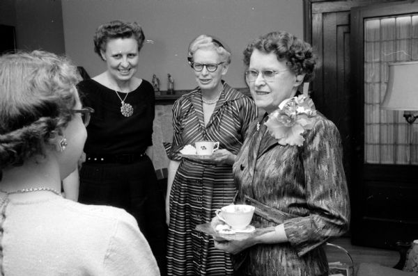 Wearing an orchid corsage (far right) is Katherine Middleton at a tea in her honor at a private home. She retired on January 1st after almost 32 years of service with the Wisconsin Free Library Commission. Others are Dorothy Naughton (foreground), S. Janice Kee (left), and France Christison (center).