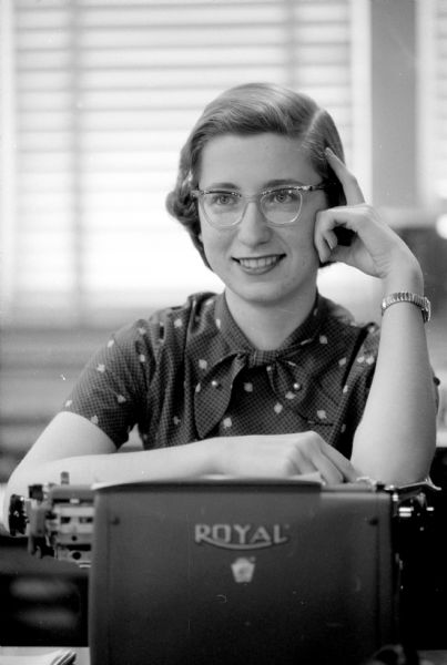 Portrait of Madison playwright Mary-Kate Lorenz. Her play, "Beauty and the Beast", will be performed by the Madison Theater Guild at the Central High School auditorium. She is seen leaning on a typewriter manufactured by Royal.