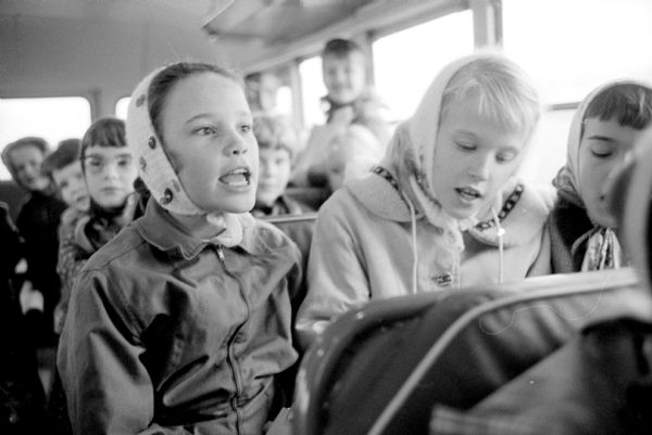 Three girls singing while riding on the school bus from Dudgeon School to Blackhawk Park.