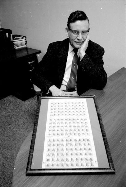 Harold Myhre, a philatelist and head of the Madison Stamp Club, with a display of some of his valuable stamps that are framed.
