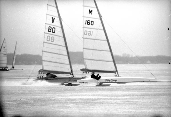 Dave Roston (Madison) skippers "Flying Trump", a Skeeter ice boat (right) around a marker in the International Skeeter Association regatta on Lake Mendota. Frank Trost of Pewaukee guides "Tuscanora IV" (left) around the same turn on the inside of Roston. Roston won the morning's race.