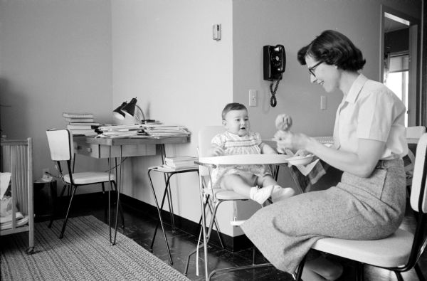 Mrs. R.W. Doskotch serves lunch to her baby daughter Donna Leisa at their unit in the U.W. Eagle Heights graduate students apartments. Mr. Doskotch earned his M.S. degree from the University of Wisconsin and is studying for his doctorate in biochemistry. The Doskotchs are natives of Canada.