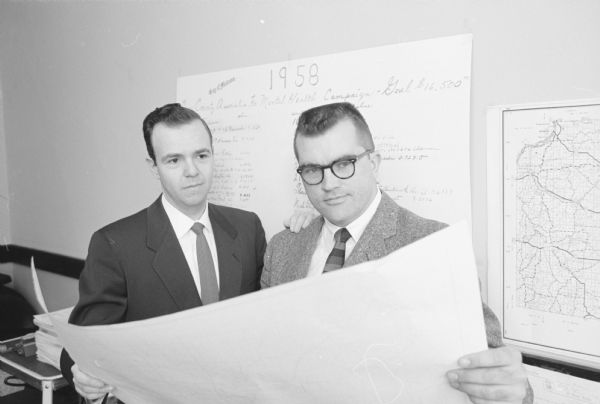 Association president, Howard Hershleder, and campaign chairman, H. Kelley Meyer, look over a chart in preparation for the annual fund drive of the Dane County Association for Mental Health.