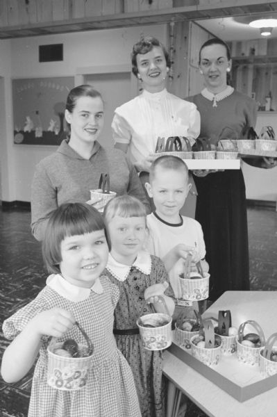 Three members of the Alpha Xi chapter of Epsilon Sigma Alpha sorority delivered Easter baskets to the young tuberculosis patients at the Morningside sanatorium. They are shown with three unidentified children holding the baskets. The sorority members are L. Claire Armbrecht, Sally Frankey, and Bernice Van Tassel.