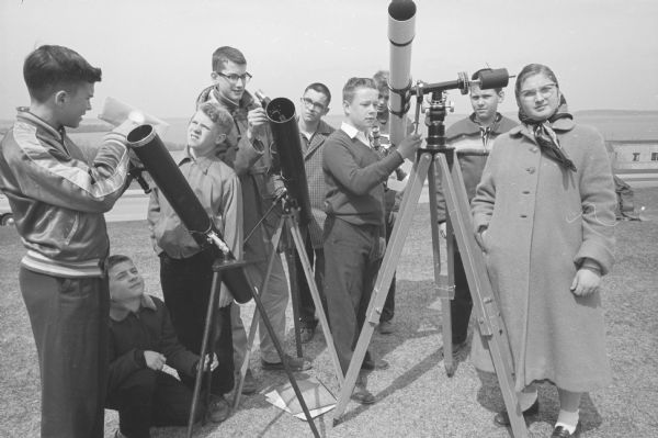 A group of Madison youth inspecting and setting up their telescopic equipment for gazing at the skies. This photograph accompanied an article about the growing interest in astronomy after the launch of Sputnik I. 