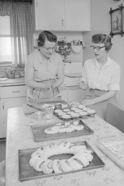 Kathleen Russell, Iowa County home agent, at the home of Mrs. Ivan Johanning, Dodgeville. They are admiring the baked goods made by Mrs. Johanning as one of a homemakers project.