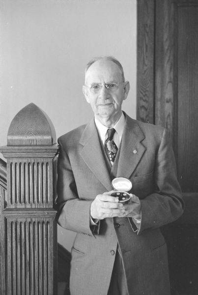 Harvey C. Dollison, a coin collector, is shown holding a round container displaying California Gold Rush era privately minted 25 and 50-cent gold pieces that he bought in New Orleans in 1920.