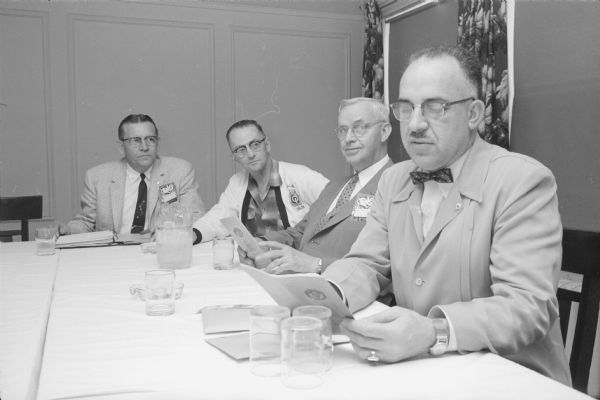 Members of the nominating committee get to work at the district convention of Optimists International at Hotel Loraine. Left to right are: Arthur Schmidt, Milwaukee; William N. Kerfuat, Duluth, Minnesota; W. Starr Nichols, Madison; and Dr. Raymond R. Rembolt, Iowa City, Iowa.