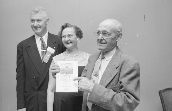 Some of the "advance guard" for the Sons of Norway district convention at Hotel Loraine. Left to right are: Bernard Jacobson, Evanston, Illinois, district president; Mrs. Margaret Hansen, Sun Prairie, registrar; and Alfred Ellickson, Madison, secretary of the host lodge. Alfred is holding up the Twenty-fourth Biennial Convention of the Sons of Norway Fifth District booklet.