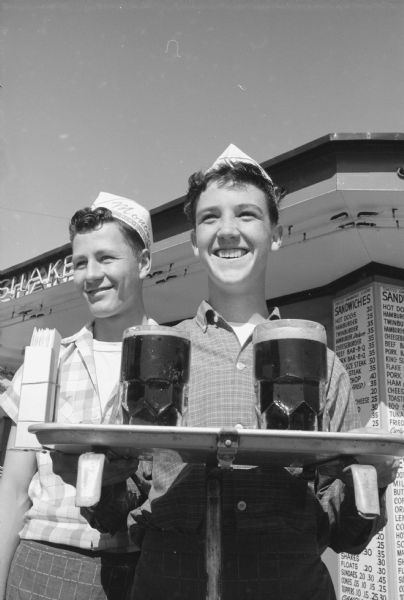 James Fernan, 3522 Dennett Drive (left), and Harold Hemel, 738 Lansing Street (right) serving up root beer at a Monona drive-in.    