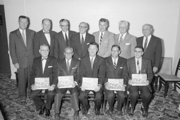 Members of the board of directors of the Madison Improvement Corporation that unwrapped plans to increase the industrial potential of the Madison metropolitan area. Seated, from left, are: Paul H. Schroeder, Ray Messner, Henry Behnke, Atty. Leon Isaksen, and J. Martin Wolman. Standing in back, from left, are:c
 A.E. Friede, Atty. John J. Walsh, Walter A. Frautschi, L.L. Lunenschloss, John Fox. F.H. Elwell, and C.N. Goulet.