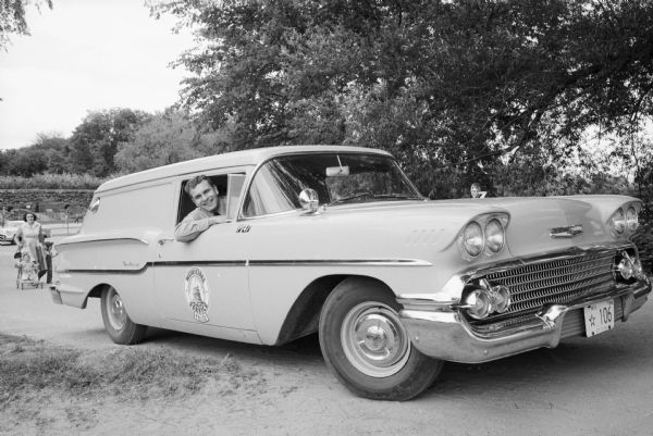 William Wurtzler leans from the window of the city's new dog-catching wagon, a two-door four window, 1958 Ford station wagon. Wurtzler, the son of Police Sgt. Walter Wurtzler of the patrol division, is a provisional appointee in the job.
