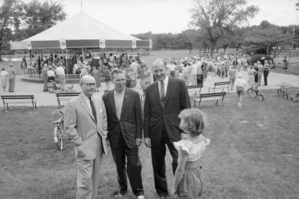 Attending the grand opening of the Vilas Park merry-go-round are, (L-R): Lawrence H. Fitzpatrick, <i>Wisconsin State Journal</i> managing editor; Robert C. Voss, 1214 Edgehill Drive; and Madison Mayor Ivan A. Nestingen, all talking to Barbara Randall, Markesan. Voss suggested the fund drive to finance the merry-go-round.  