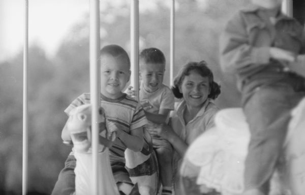 Children ride horses on the new merry-go-round at Vilas Park. The grand opening for the merry-go-round occurred on June 21, 1958.