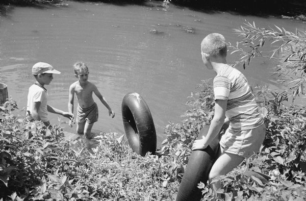 Three boys prepare to launch their home-made raft on Murphy's (Wingra) Creek. The boys are Mike Webster, 709 Emerson Street; Jerry DuBois, 213 W. Lakeside Street; and Sven Erich "Butch" Ranzen, 620 Cedar Street. 
