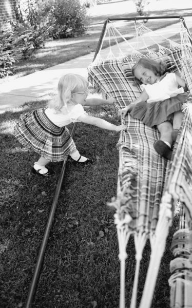 Laurie Stein, 5 year old daughter of photographer Edwin Stein, playing in a double hammock with her friend Sara.