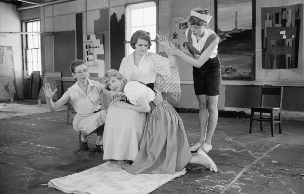 Mary-Kate Lorenz, left, directs Anna Lee Henningsen, seated, Lois Suomi, kneeling, and Ann Mannering, standing, in the spanking scene from Youth Summer theater's "Jack and Jill". A morning and afternoon cast of the actors are touring the city's parks and playgrounds.