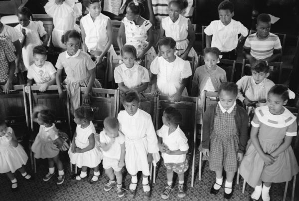 Elevated view of a large group of African-American children. They are attending summer Bible school at their church, Second Baptist Church at 827 Mound street.
