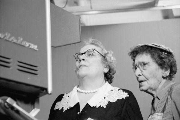 Members from Madison's five Senior Citizens groups tour the University of Wisconsin television station WHA-TV. Shown looking through a television camera are, (L-R): Mrs. Evangeline Knapp, 1340 Jenifer Street; and Mrs. Grace Ware, 1335 Williamson Street.