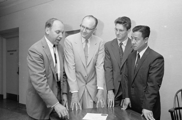 One in a series featuring faculty and students who participated in a nine week orientation economic study for foreign students. Principals at the closing ceremony include, left to right: institute director Prof. Wyn Owen, University of Colorado, and Dr. Fred Harrington, U.W. vice-president. They are shown with students Claude Maurice Jules Allais, France and Ching-Fu Hsiao, China.