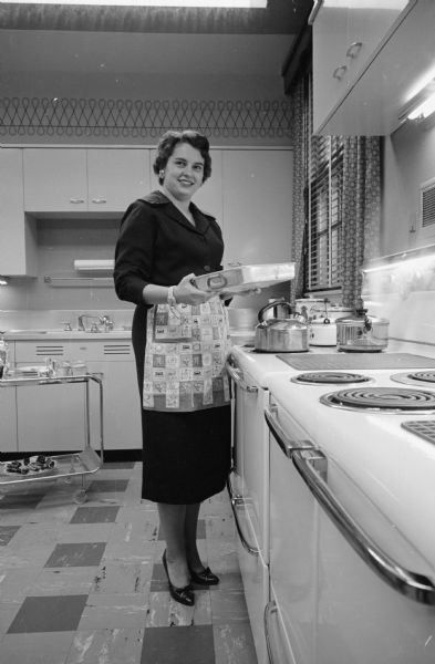 University of Wisconsin president Conrad A. Elvehjem's daughter, Peggy, a home economist with General Mills in Minneapolis, standing in the kitchen of Olin House, which was then the official residence of the University president.