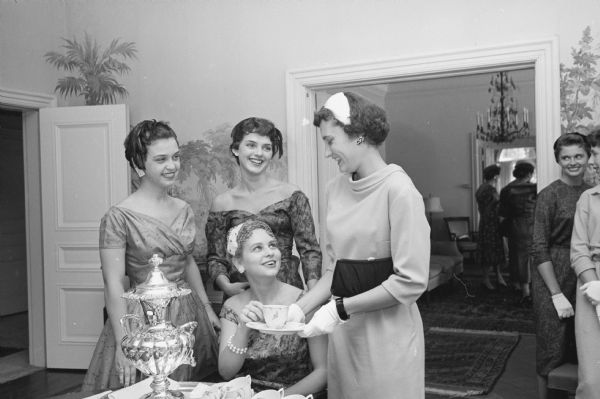 Members of the Madison Dental Hygiene Association hold a tea at the Governor's Mansion in Maple Bluff. Shown seated is: Mary Lou Kirby, 305 N. Pinckney Street, and standing left to right are: Judy Siemann, 305 N. Pinckney Street; Donna Hyland, 305 N. Pinckney Street; and Sally Sanger, 1 Langdon Street.