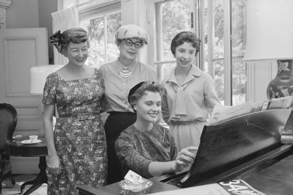 Members of the Madison Dental Hygiene Association hold a tea at the Governor's Mansion in Maple Bluff. Shown listening to Louise Dostal, 205 N. Randall Avenue, play the governor's piano are, (L-R): Margaret Schlueter, Milwaukee, Marquette University assistant professor of dental hygiene; Jean Heinke, Milwaukee, Marquette University dental hygiene staff member; and Barbara Costello, 205 N. Randall Avenue.