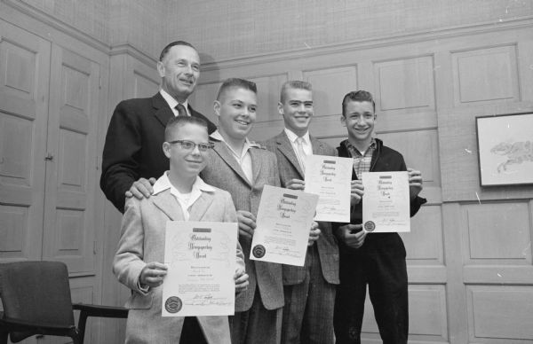 Four Wisconsin State Journal carrier boys show off their National Newspaperboy Awards with publisher Don Anderson. The boys are, left to right: David Lee, Dave Lythjohn, Dick Link, and Ron Ayen.