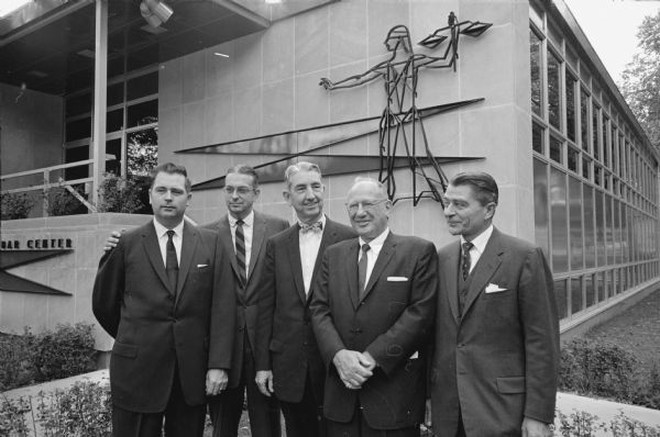 United States Supreme Court Justice Tom C. Clark, center, was the main speaker at the dedication of the new headquarters for the State Bar of Wisconsin at 402 West Wilson Street. Other men are, left to right: Philip S. Habermann, Herbert L. Terwilliger, Charles L. Goldberg, and Francis Wilcox. The nine-foot figure of justice on the building wall was designed by Professor James S. Watrous, chairman of the art history department of the University of Wisconsin.