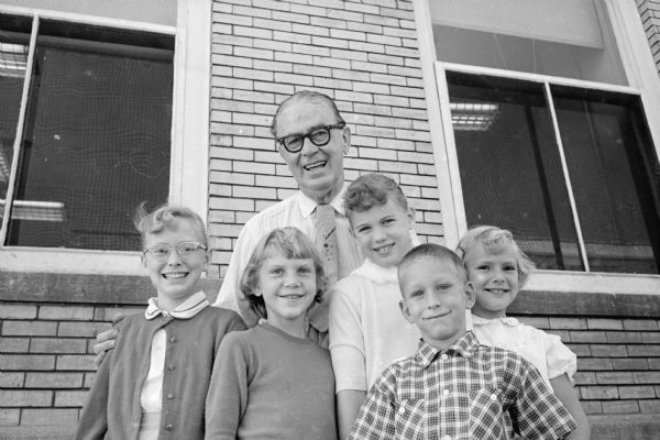Wisconsin State Journal reporter, Joseph "Roundy" Coughlin poses with five kids who raised money for "Roundy's Fun Fund". Members of the summer Busy Bees club are, left to right: Lois Ulvestad, Cheryl Williams, Joy Anne Olson, Arlean Ulvestad, and Hugh Sloan.