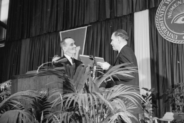 University of Wisconsin Regent President Wilbur Renk presents a bound certificate of appointment as president of the university to Dr. Conrad A. Elvehjem during the inaugural ceremonies at the field house.