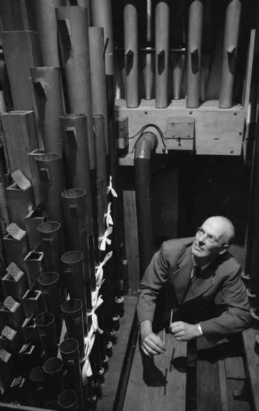 H. Frederick Fuller, a Madison organ architect, stands by some of the pipes of the organ he reconditioned at Grace Episcopal church. The organ was originally built in 1917 for the Kimball hall in Chicago and was purchased for the church by Fletcher Wheeler, a prominent Madison musician who was the church organist at the time.