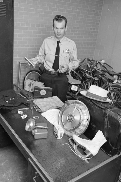 Madison policeman Duane Haralson prepares items for the annual police department auction to be held in the basement of the City-County Building.