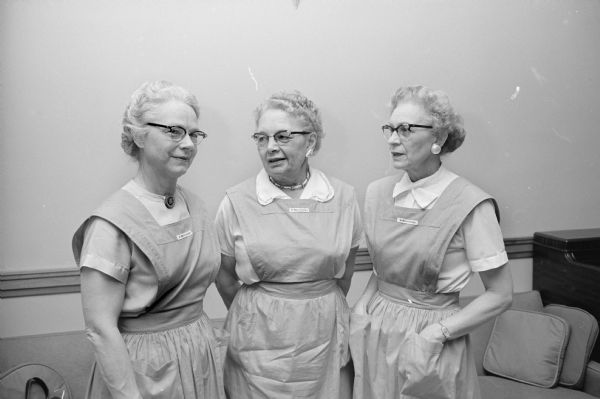 Three of the auxiliary members of St. Mary's Hospital attending their annual tea. Wearing their uniforms are, left to right: Mrs. Eugene Connor, Rose Haley, and Helen Elliott.    