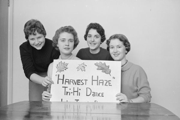 Members of the Tri-Hi high school teenager's group promote the group's "Harvest Haze" dance to be held at the new Labor Temple on South Park Street. The dance is open to all teen-agers in the city of Madison. Shown (L-R) are: Kathy Sanna, Fox Bluff Lane; Mackie Lippolt, 4259 Mohawk Drive; Cookie Bolgrien, 1 Hiawatha Circle; and Nancy Lewis, 1107 Amherst Drive.     