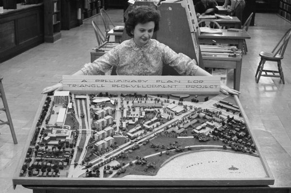 Madison library assistant Mrs. Ronald Labott, 313 S. Marquette Street, examines a model of the Brittingham redevelopment model. The "Triangle" redevelopment area is located between S. Park Street, Regent Street, W. Washington Avenue and W. Main Street. The project includes low-rise garden apartment buildings, four story high-rise apartment buildings,   a medical center, a Madison General Hospital annex, and a shopping center.       