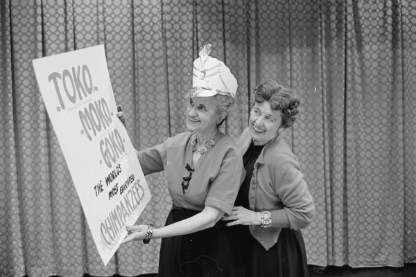 Two participants in the vaudeville show at a meeting of the Woman's Club of Madison admire a poster for one of the acts. They are Marie Oakey and Grace Livesey.
